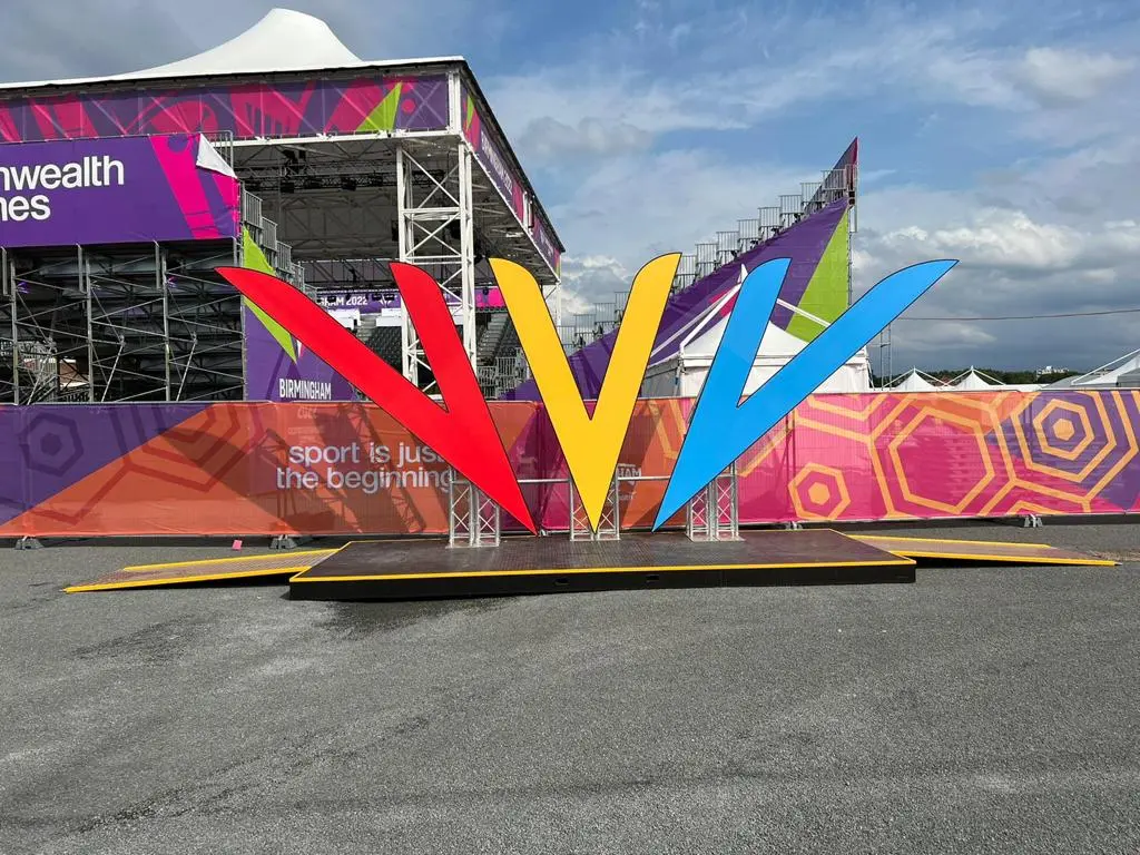 Large Commonwealth Games logo display with event branding in the background